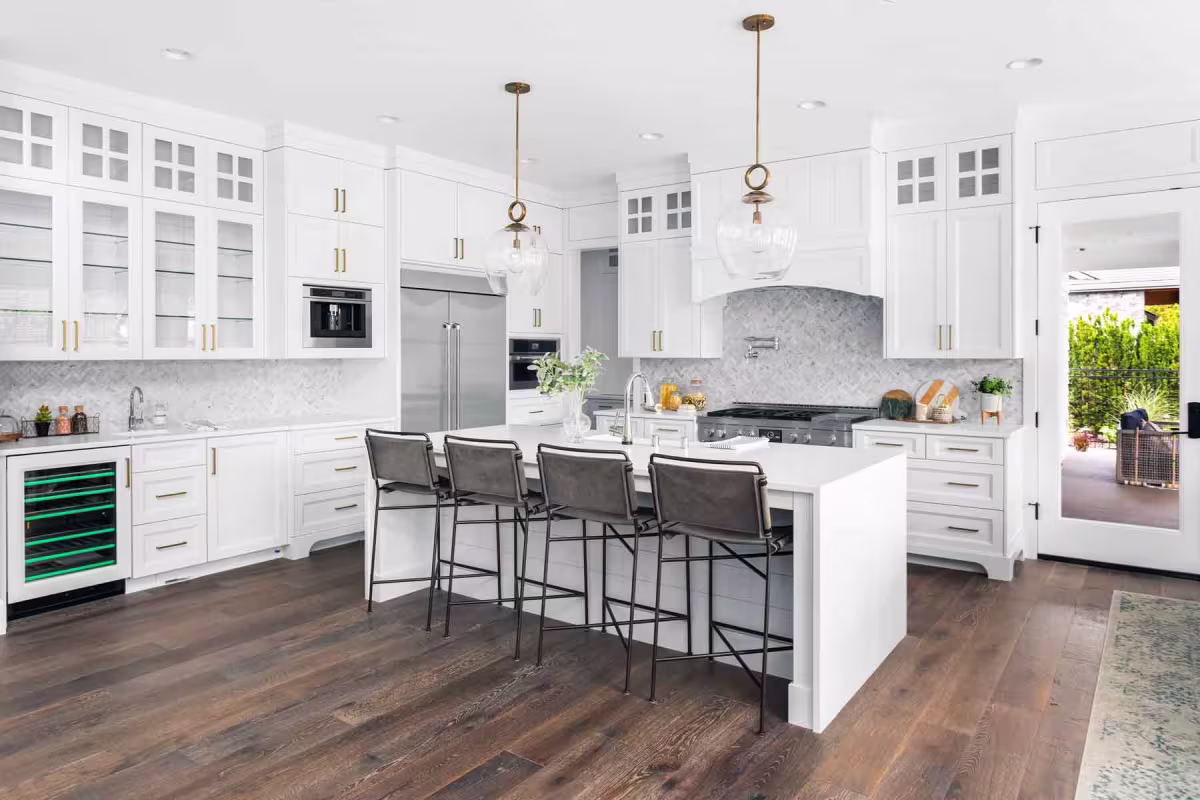 Modern kitchen remodel with white cabinetry, island seating, and pendant lights