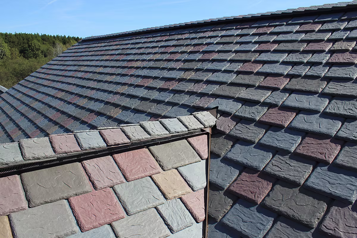 Synthetic slate roofing tiles installed on a residential rooftop with ridge line view